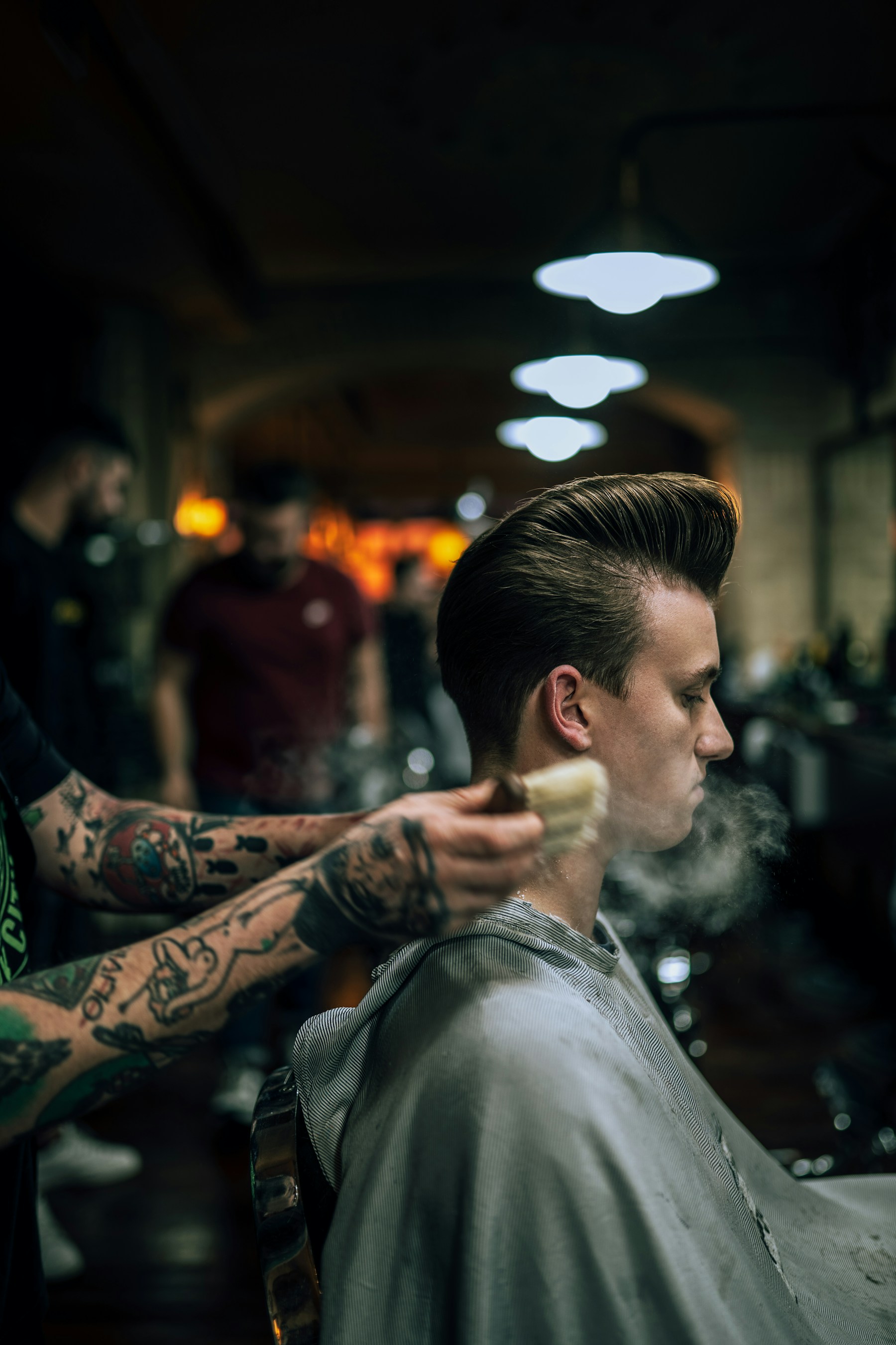 Barber carefully finishing a client's haircut